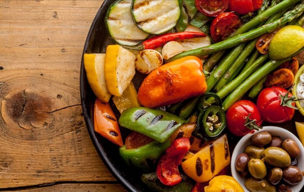 roasted vegetables in plate over wooden table