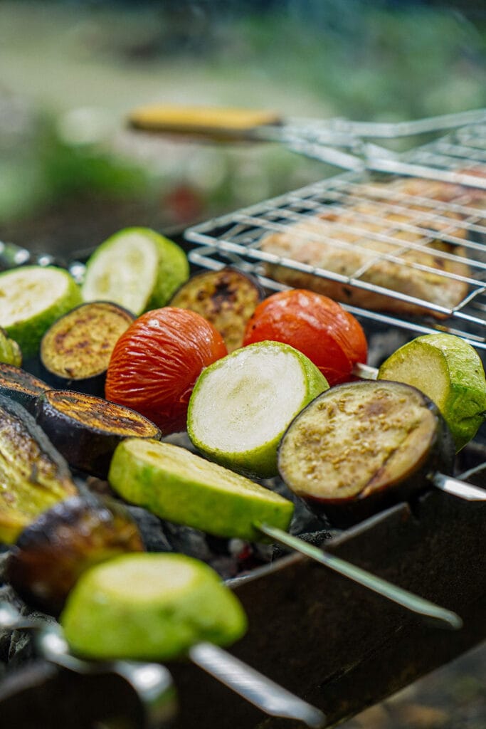 sliced vegetables on skewers on grill